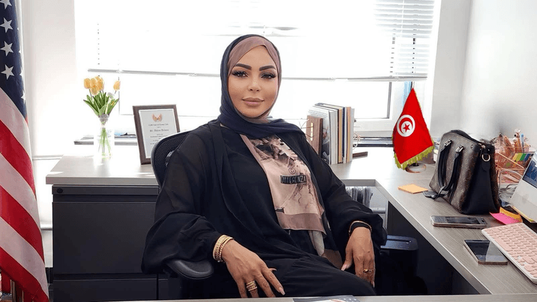 Dr. Ahlem Arfaoui Tartir seated in her office, symbolizing leadership in immigration reform and refugee protection.