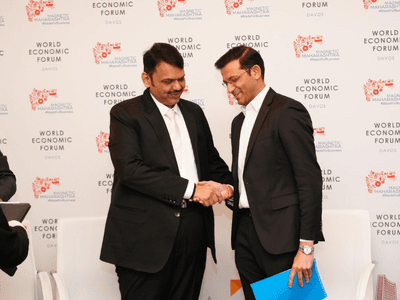 Darpan Jayraj Kale and Devendraji Phadnavis shake hands at the World Economic Forum, announcing AI infrastructure collaboration.
