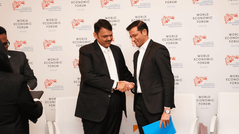 Darpan Jayraj Kale and Devendraji Phadnavis shake hands at the World Economic Forum, announcing AI infrastructure collaboration.