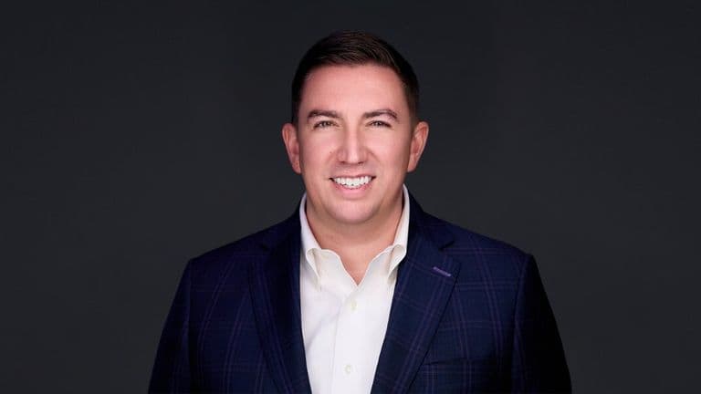 A smiling man in a suit and tie, representing confidence and professionalism in a legal context.