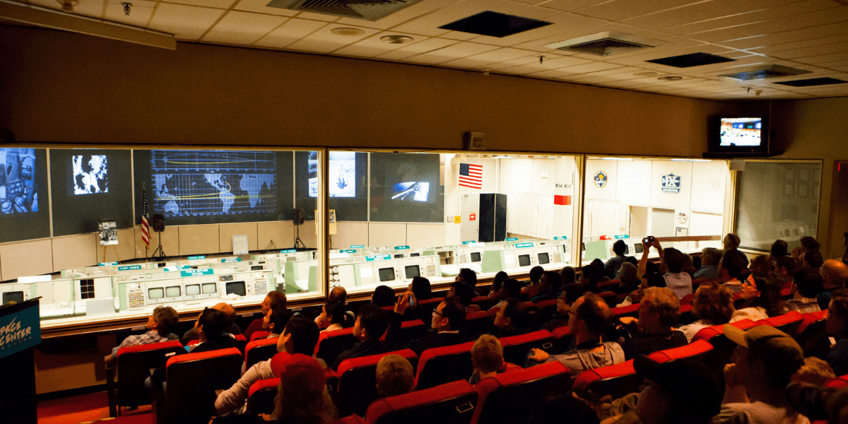 Interior of a control room with a large audience facing screens and displays