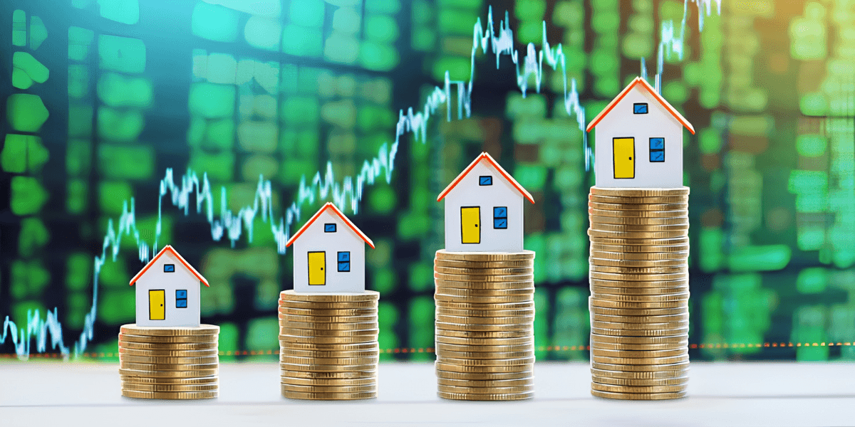 Increasing stacks of coins with miniature houses and a rising graph in the background