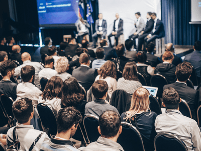 Audience attentively watching a panel discussion on stage at a conference event