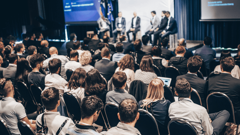 Audience attentively watching a panel discussion on stage at a conference event