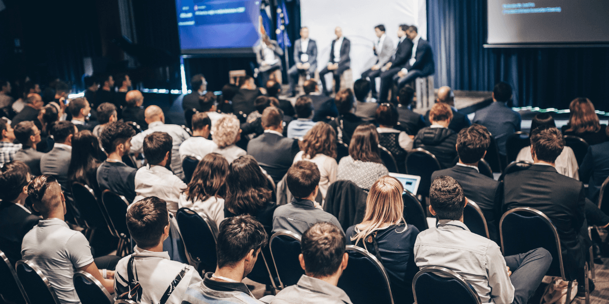 Audience attentively watching a panel discussion on stage at a conference event