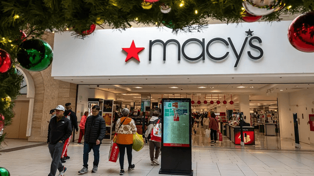 Macy's store entrance decorated for the holidays with shoppers walking inside