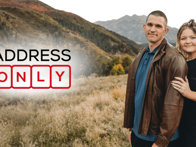 A couple stands together in a scenic mountain landscape with text overlay "ADDRESS ONLY"