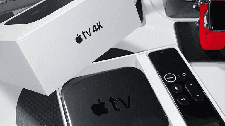 Apple TV 4K in its box with remote and an Apple Watch nearby