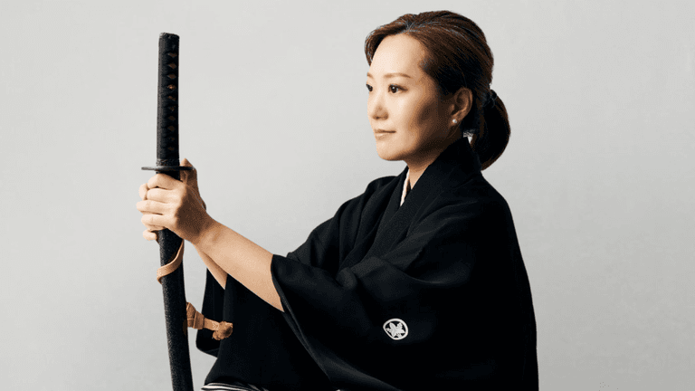 Woman in traditional kimono holding a katana, symbolizing samurai discipline and mental focus.