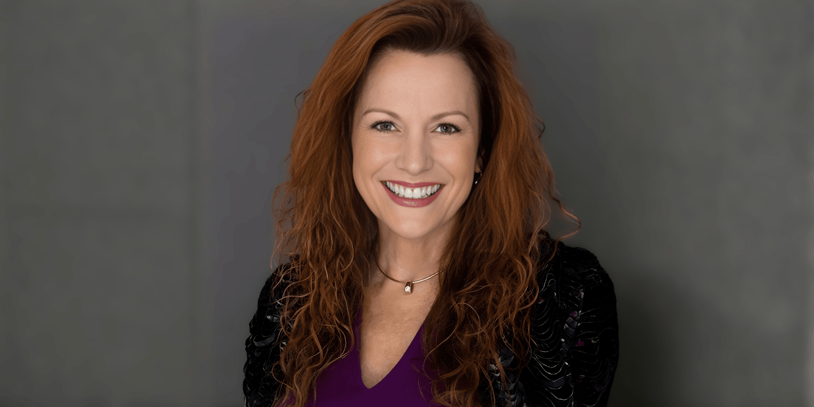 Nancy Prince, experienced real estate leader, smiling while holding a business report, reflecting leadership and innovation in real estate."