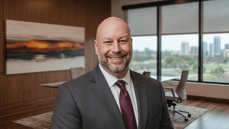 Smiling business executive in a modern boardroom with city skyline visible through large office windows.