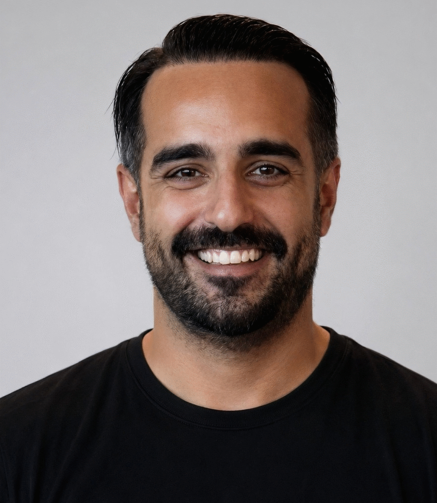 Headshot of WitSpeak founder Fatih Can Yildirim wearing a black shirt against a light background.